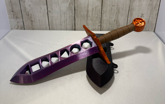 3D-printed dice sword with pink blade, orange pommel, brown handle, and matching sheath.