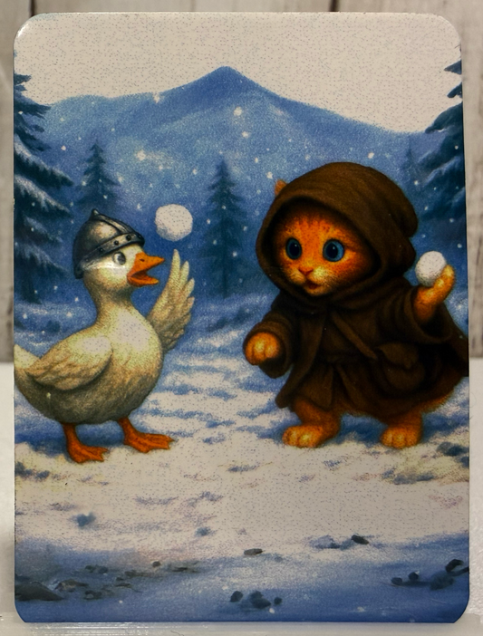 Magnet featuring a cat in a hooded outfit and a goose playing with snowballs in a snowy landscape.