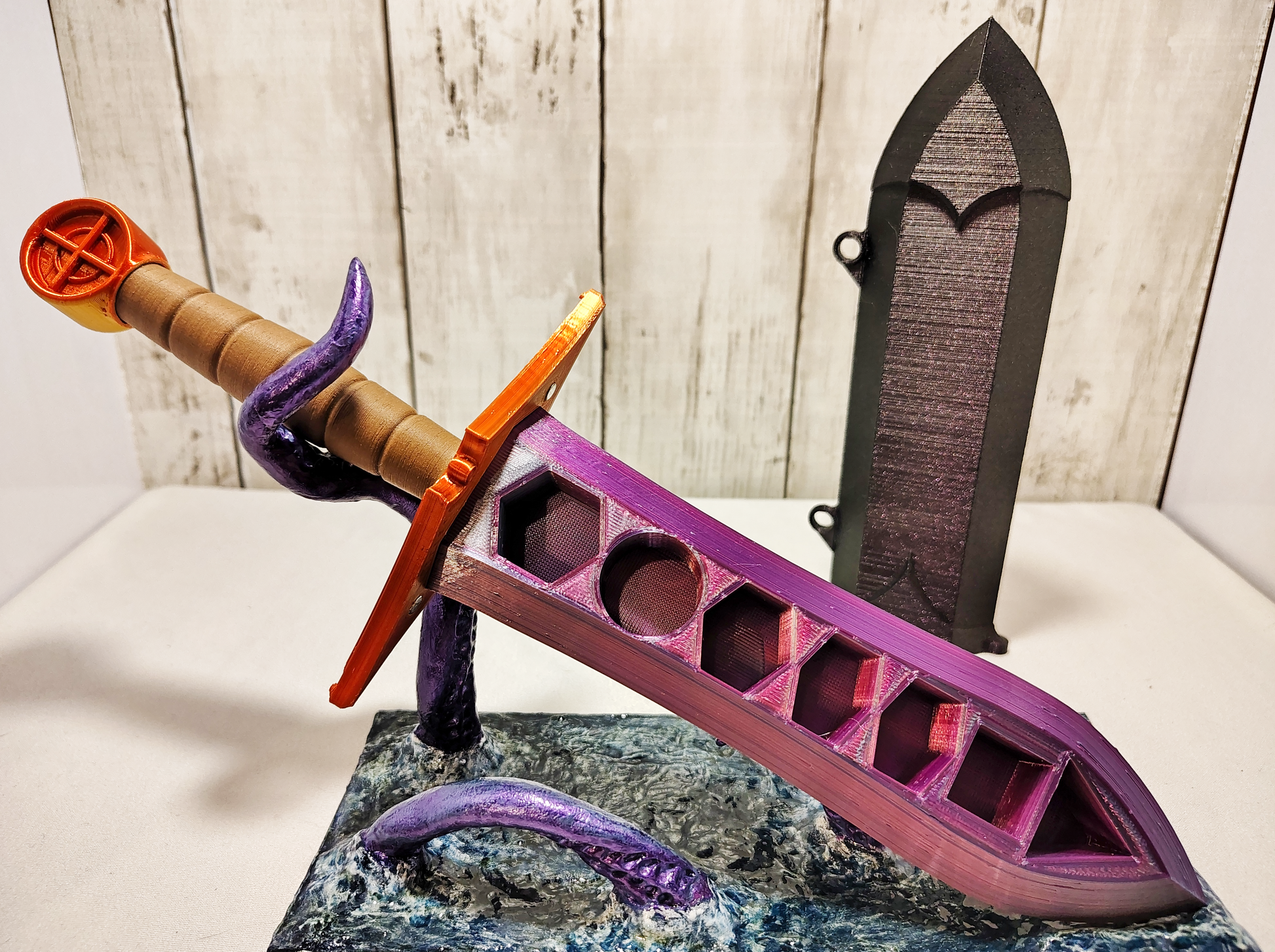 3D-printed dice sword with pink blade, orange pommel, brown handle, and matching sheath.