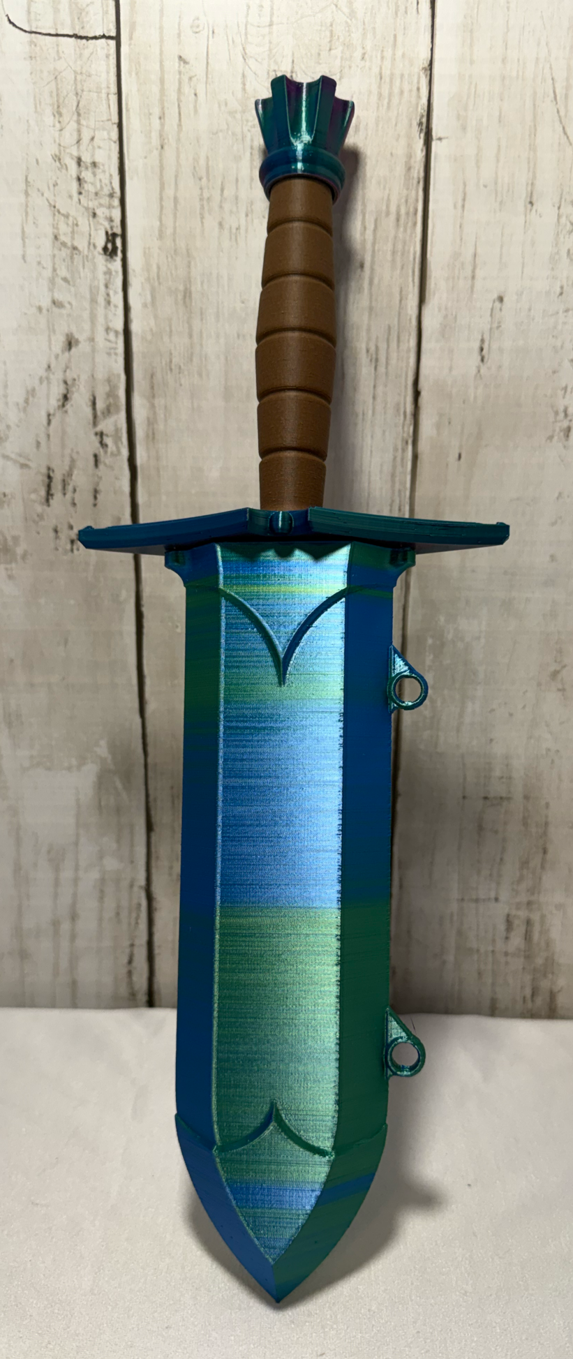 3D-printed dice sword with neon green blade, green pommel, brown handle, and matching sheath.