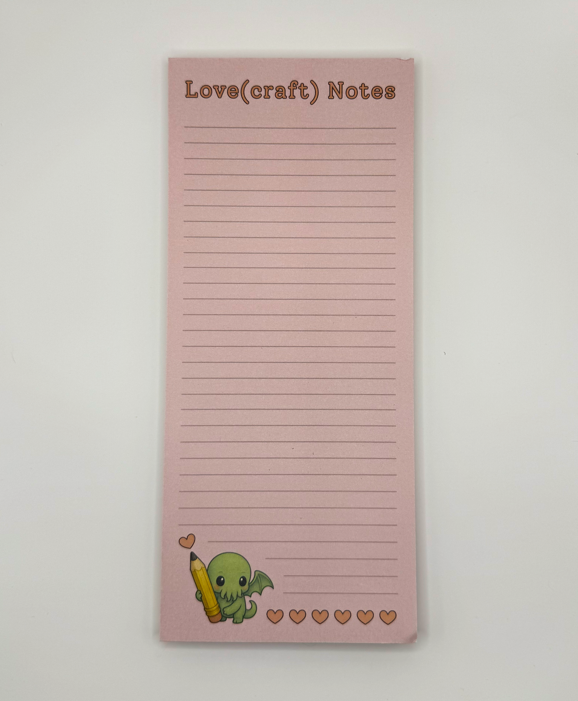 Love(craft) Notes - lined notepad featuring chibi Cthulhu holding a pencil, drawing hearts