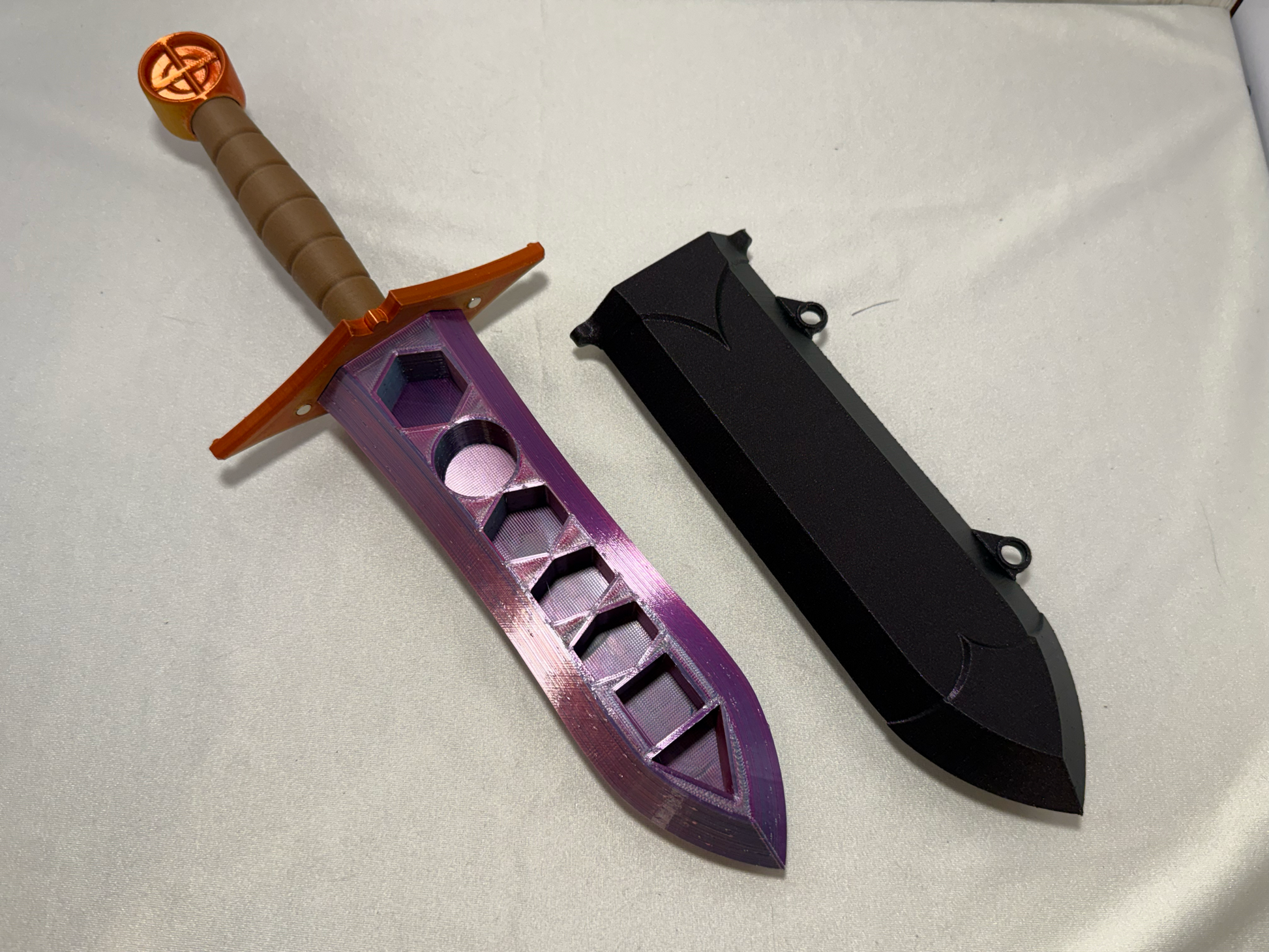3D-printed dice sword with pink blade, orange pommel, brown handle, and matching sheath.