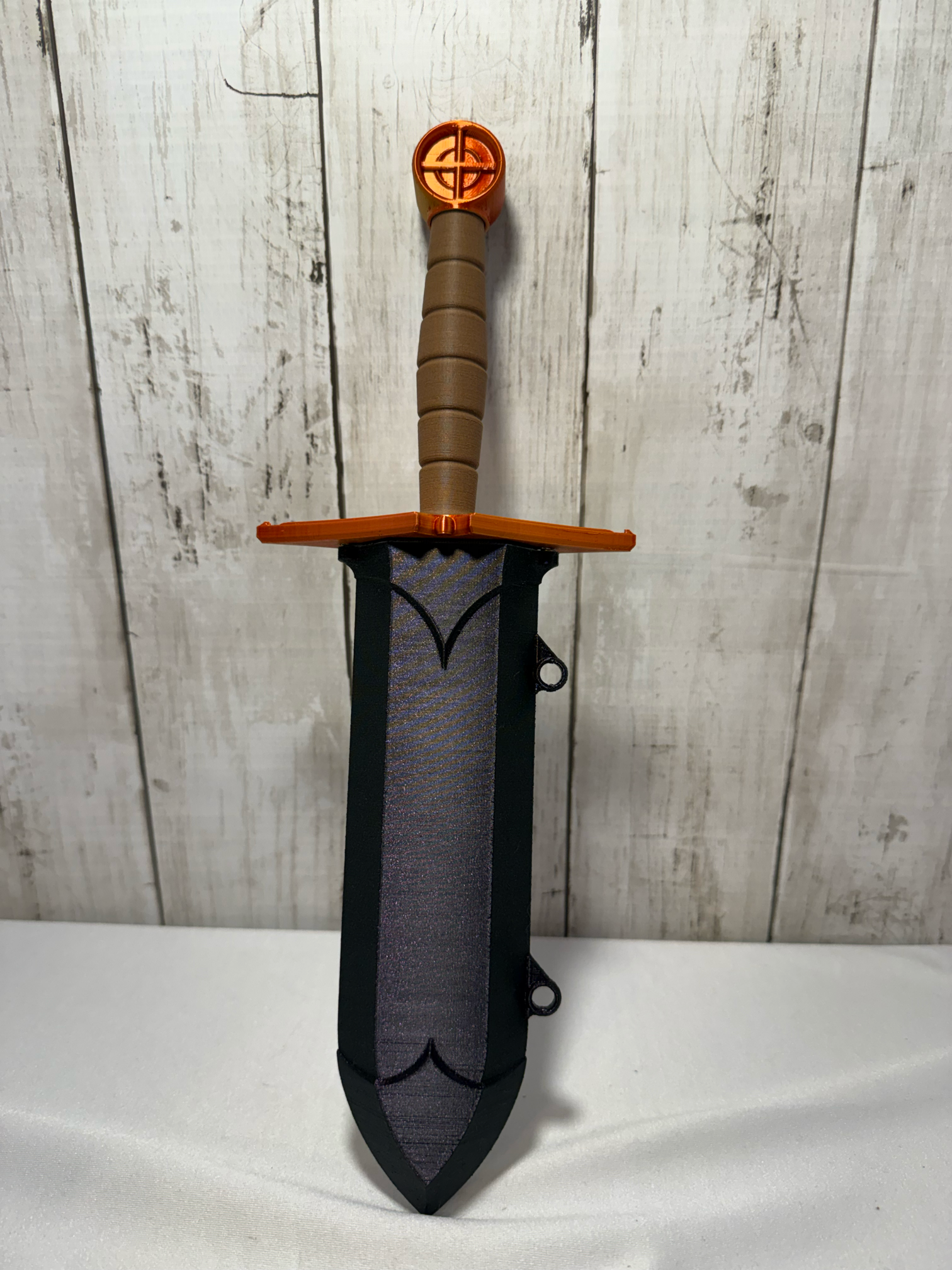 3D-printed dice sword with pink blade, orange pommel, brown handle, and matching sheath.