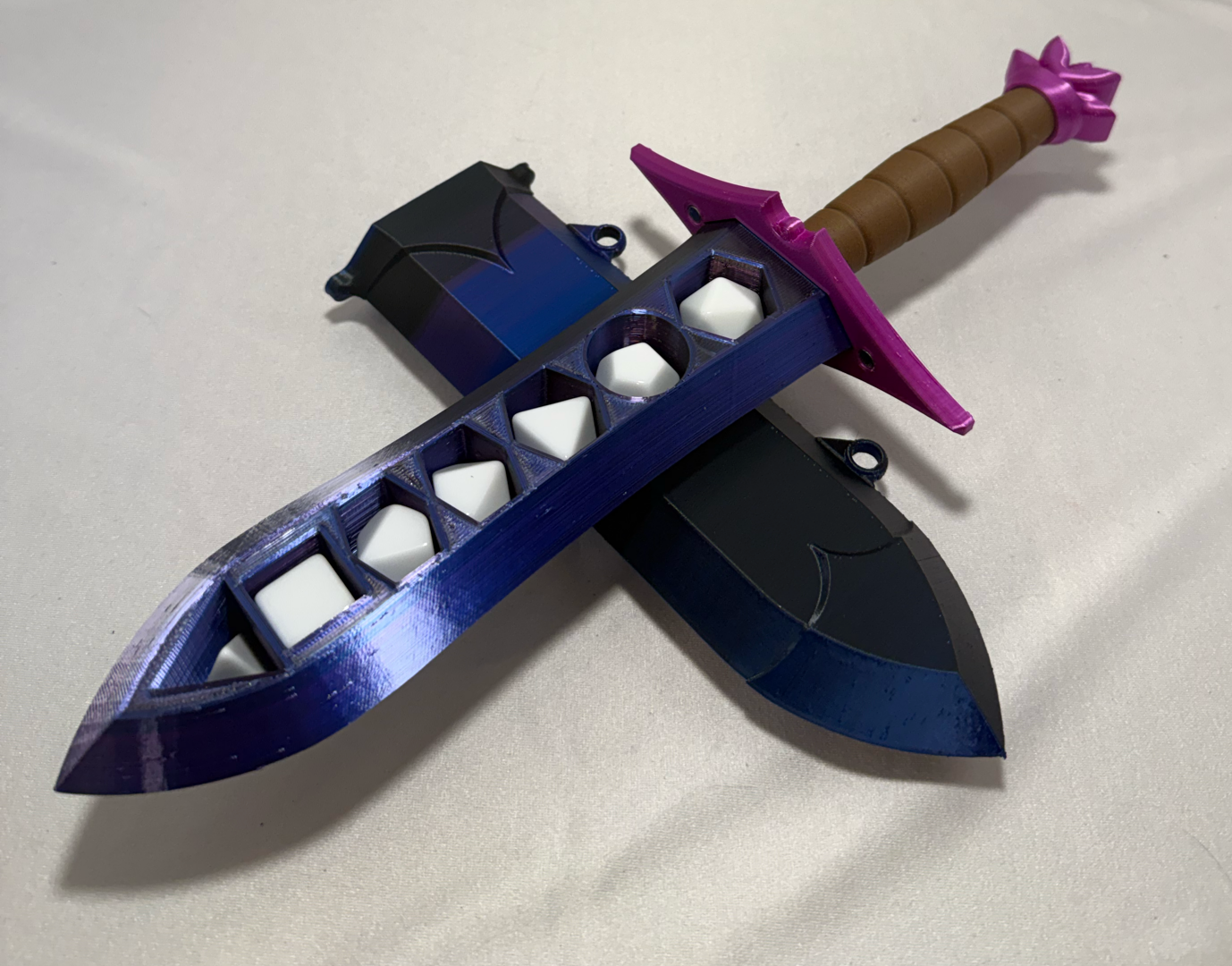 3D-printed dice sword with purple blade, pink pommel, brown handle, and matching sheath.
