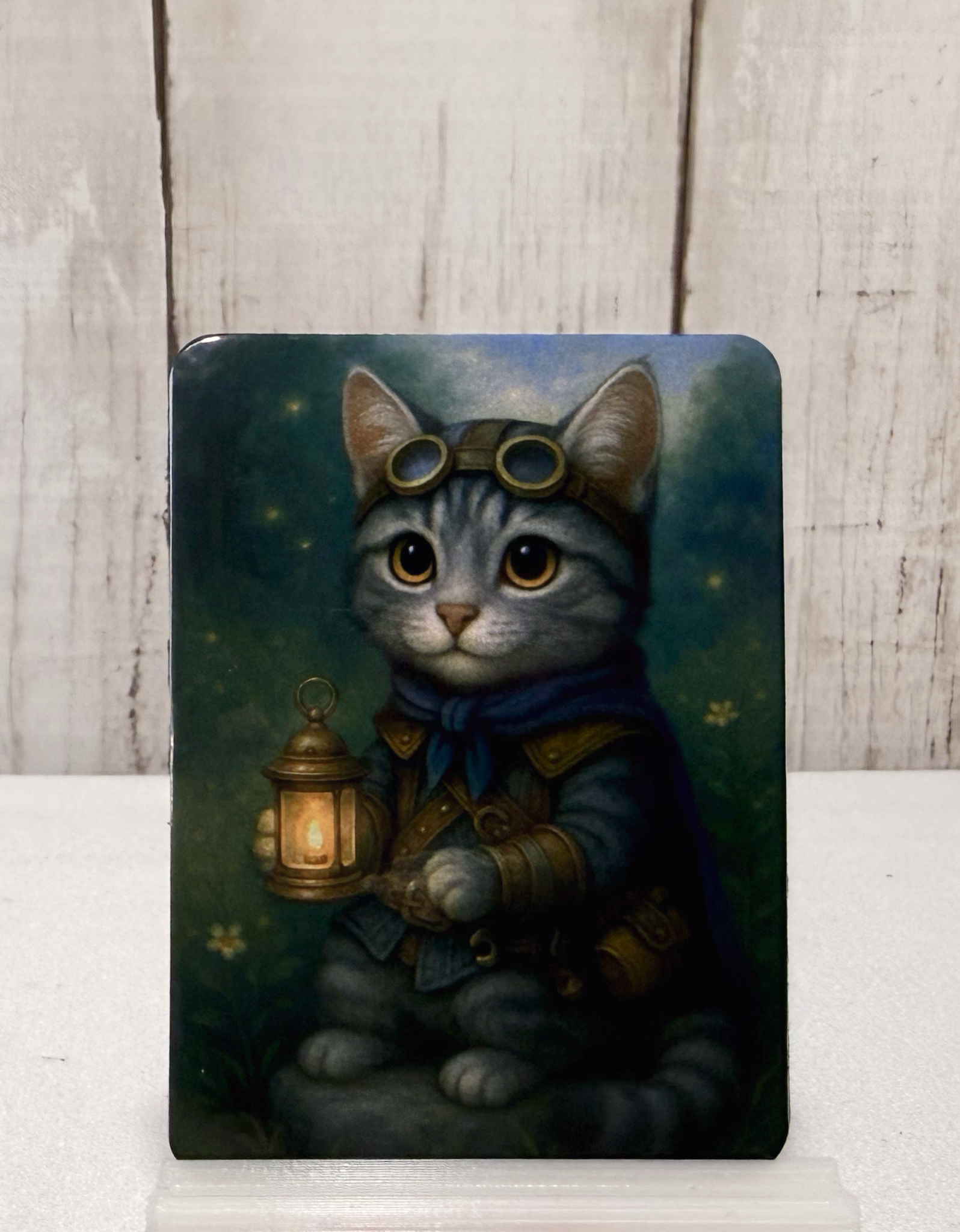 Magnet featuring a cat in steampunk attire holding a lantern against a dark background.
