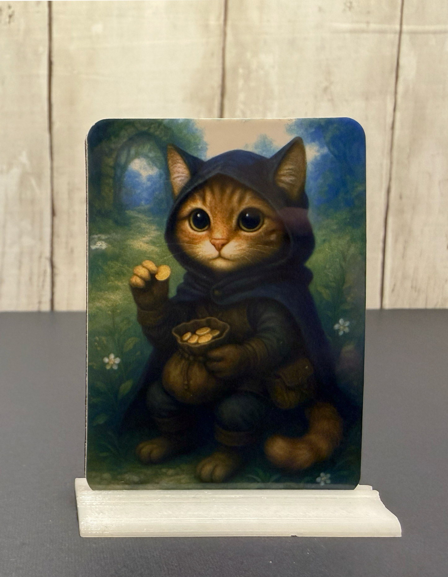 Magnet featuring a thief cat in a hooded cloak holding gold coins