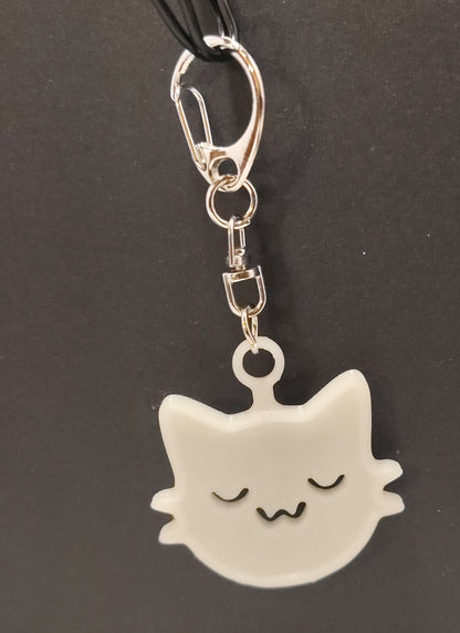 White cat-shaped keychain with a silver swivel clasp on a dark background